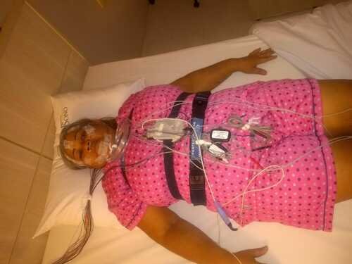 girlene deitada, com aparelhos por todo o corpo